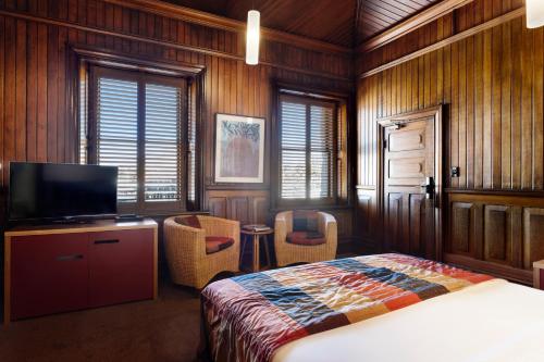 a bedroom with a bed and a flat screen tv at The Henry Jones Art Hotel in Hobart
