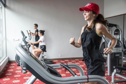 Kobieta biegająca na bieżni w siłowni w obiekcie Muong Thanh Luxury Ca Mau Hotel w mieście Cà Mau