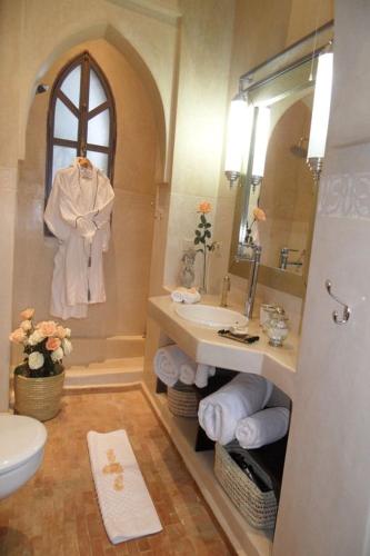 a bathroom with a sink and a toilet and a mirror at Palais Lona in Marrakesh