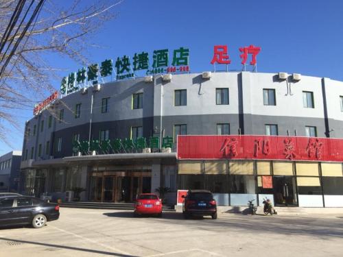 a large building with cars parked in a parking lot at GreenTree Inn Beijing Tongzhou District Yujiawu Technology park Express Hotel in Tongzhou