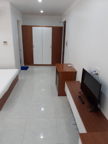 a living room with a flat screen tv and a desk at Sao Kim in Cà Mau
