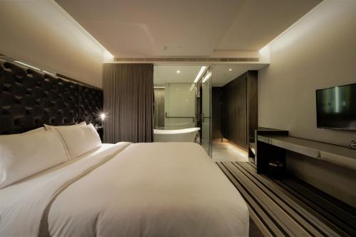 a hotel room with a large bed and a television at Starhaus Hotel in Kaohsiung