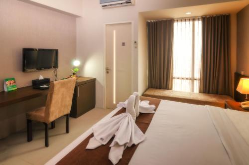 سرير أو أسرّة في غرفة في The Square Surabaya Hotel