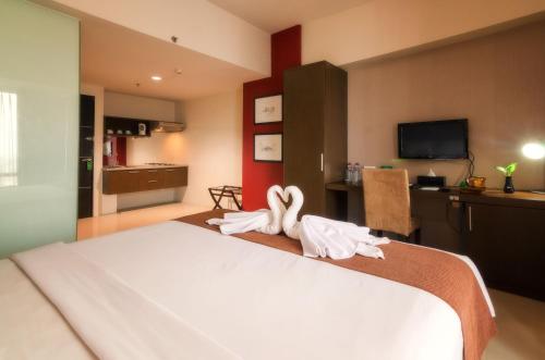 a hotel room with a bed with towels on it at The Square Surabaya Hotel in Surabaya