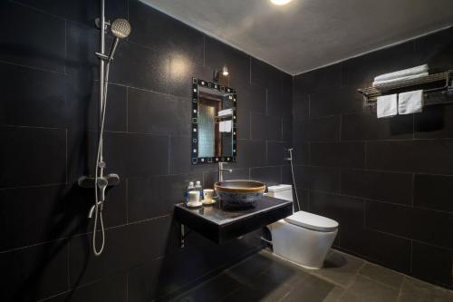 a black bathroom with a sink and a toilet at Chapa Ecolodge in Sapa