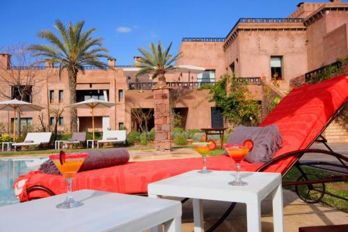 dos mesas con bebidas junto a una piscina en Kasbah Agounsane, en Ourika