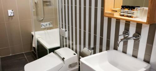 a bathroom with a white toilet and a sink at Handpicked Hotel & Collections in Seoul