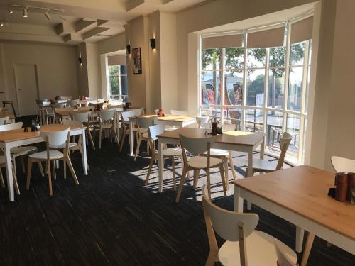 a restaurant with tables and chairs and a large window at Beau Monde International in Doncaster East