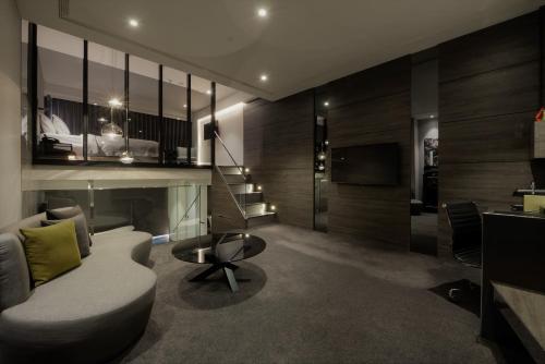 a living room with a couch and a television at Starhaus Hotel in Kaohsiung