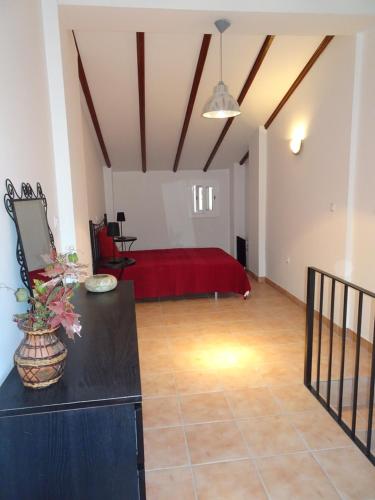 una sala de estar con una cama roja en una habitación en 9 Carrer del Forn, en Benifallet