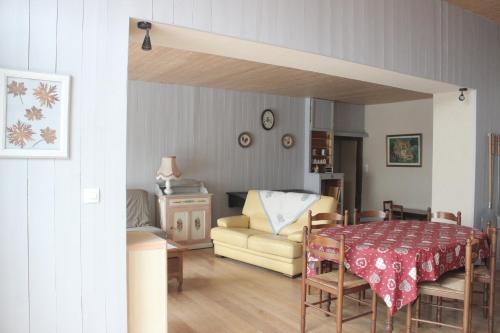 ein Wohnzimmer mit einem Tisch und einem Sofa in der Unterkunft gîte de la core in Clézentaine
