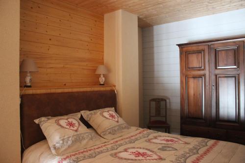 une chambre avec un lit et un mur en bois dans l'établissement gîte de la core, à Clézentaine