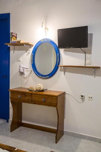 a mirror on a wall next to a wooden table at Elpiniki in Alinda