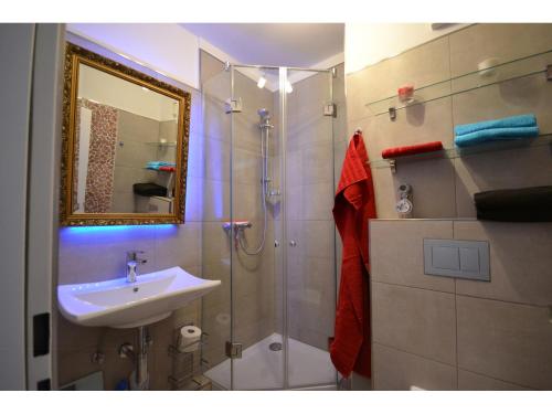 a bathroom with a shower and a sink and a mirror at Ferienapartment "Wolke" in Scharbeutz