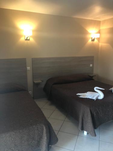 a hotel room with two beds and two towels at Hotel Clair de Lune in Zonza