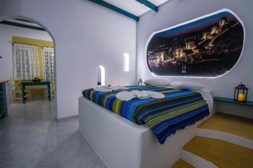 a bedroom with a bed with a tv on the wall at Elpiniki in Alinda
