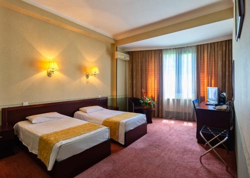 a hotel room with two beds and a television at Diplomat Hotel Baku in Baku