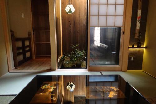 two views of a kitchen with a table in a room at Kyomachiya Ebisu Private Luxury Townhouse in Higashiyama in Kyoto