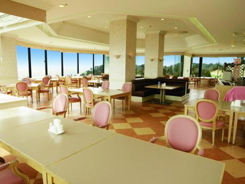 a restaurant with pink chairs and tables in a room at Onahama Ocean Hotel & Golf Club in Iwaki