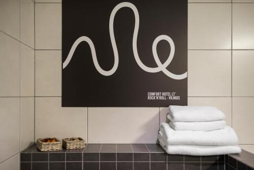 a pile of towels on a counter in a bathroom at Comfort Hotel LT - Rock 'n' Roll Vilnius in Vilnius