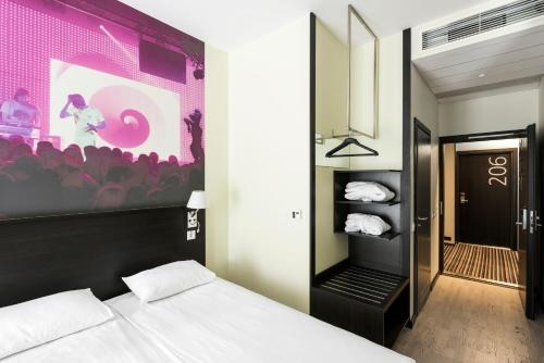 a bedroom with a bed and a large painting on the wall at Comfort Hotel LT - Rock 'n' Roll Vilnius in Vilnius