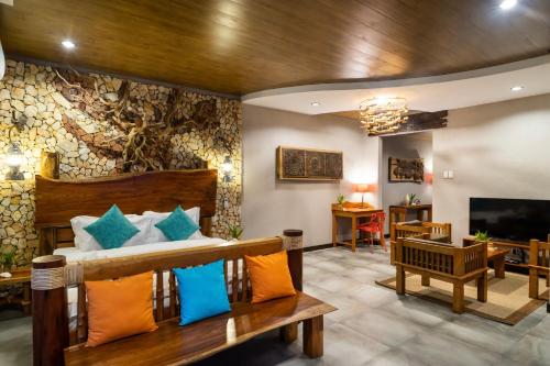 a living room with a bed and a television at La Estancia Busuanga in Busuanga