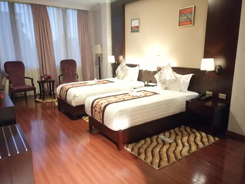 una habitación de hotel con dos camas en una habitación en Sherar Addis Hotel, en Addis Ababa