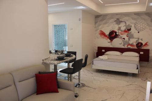 uma sala de estar com uma cama e uma mesa em Kalì B&B em Bari