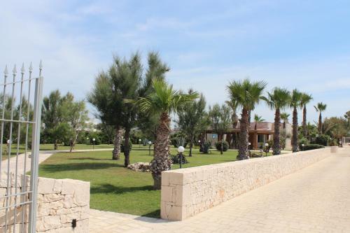 a park with palm trees and a stone wall at Kalì B&B in Bari