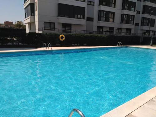 a large blue swimming pool in front of a building at Ático de Lujo en el Centro de Burgos in Burgos