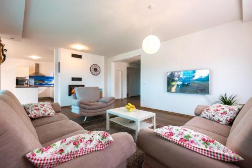 a living room with two couches and a table at Holiday Home Luma in Grabovica