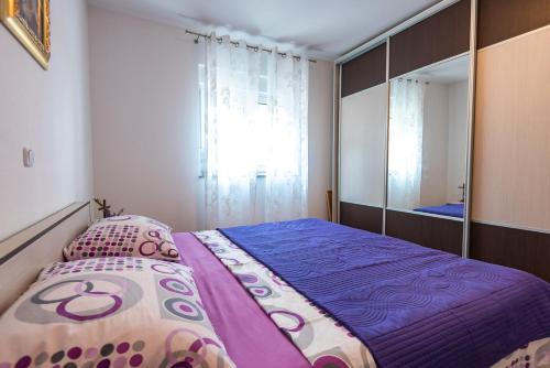 a bedroom with a bed and a large mirror at Holiday Home Luma in Grabovica