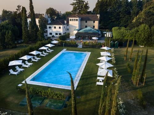 una vista aérea de una piscina con tumbonas y sombrillas en Relais et Châteaux Hotel Villa Franceschi, en Mira