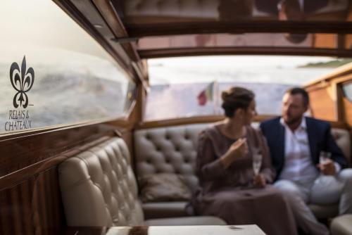 a man and a woman sitting on a train at Villa Franceschi Hotel & Resort in Mira
