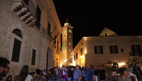a crowd of people walking down a street at night at Monolocale prezioso in Trani