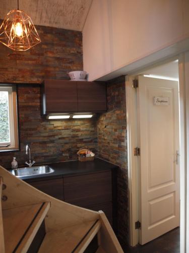 a kitchen with a sink and a counter top at Zomerhuis De Zeedistel in Egmond aan den Hoef