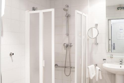 a white bathroom with a shower and a sink at Ekia Pentsioa in Zarautz