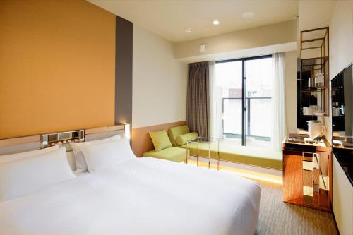 a hotel room with a large bed and a window at Candeo Hotels Tokyo Roppongi in Tokyo
