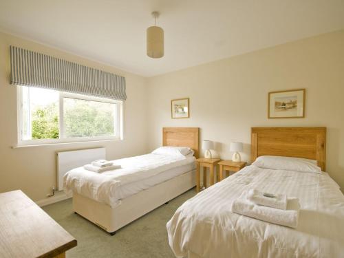 a bedroom with two beds and a window at The Meadow in Feock