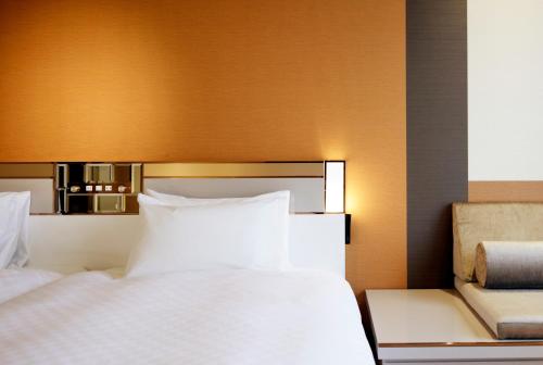 a bed with white pillows in a hotel room at Candeo Hotels Tokyo Roppongi in Tokyo