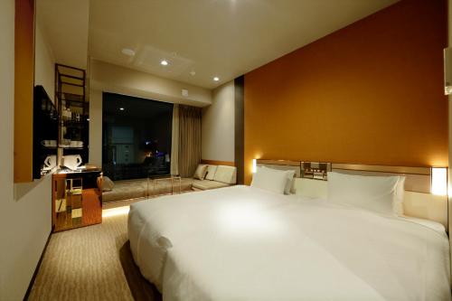 a bedroom with a large white bed and a large window at Candeo Hotels Tokyo Roppongi in Tokyo