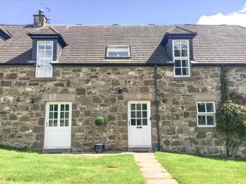 an old stone house with two white doors at Dunnottar Woods House in Stonehaven