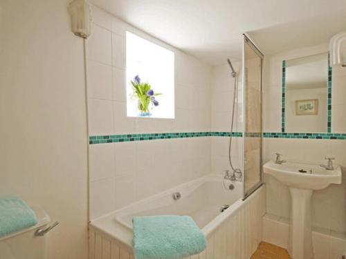 baño blanco con lavabo, bañera y aseo en Rosemaddon en Crantock