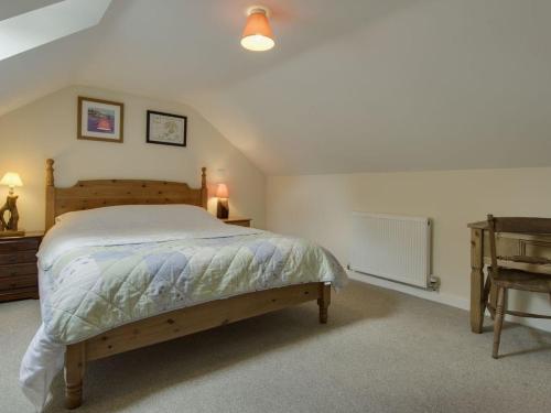 1 dormitorio con 1 cama grande y escritorio en The Old Engine House, en Bodmin