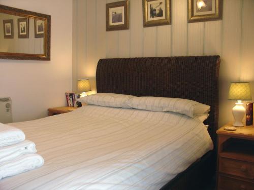 sypialnia z dużym białym łóżkiem z 2 lampami w obiekcie Millers Cottage w mieście Bude