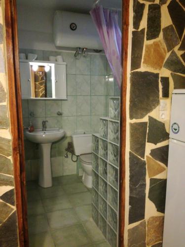 a small bathroom with a toilet and a sink at Apartments Zoumperi in Nea Makri