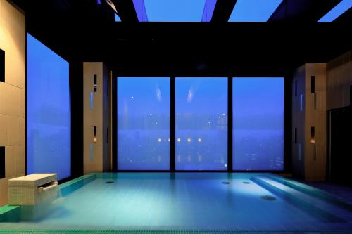 a room with a swimming pool in a building with windows at Candeo Hotels Tokyo Roppongi in Tokyo