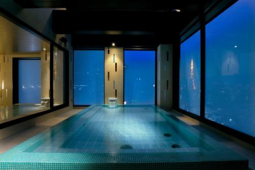 a swimming pool in a building with windows at Candeo Hotels Tokyo Roppongi in Tokyo