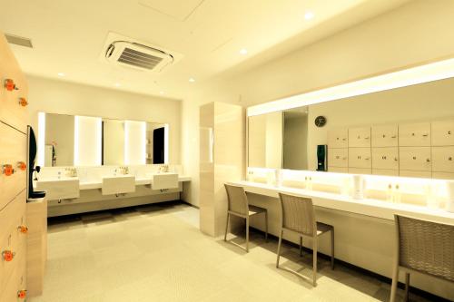a large bathroom with white sinks and mirrors at Candeo Hotels Tokyo Roppongi in Tokyo