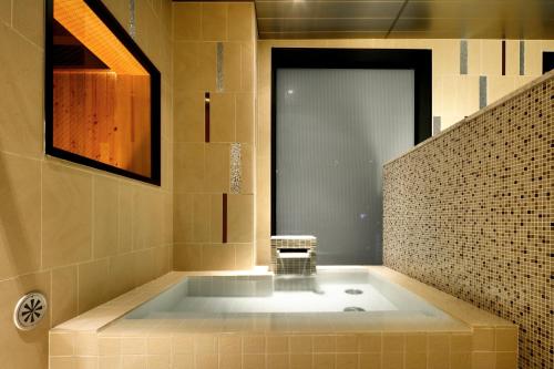 a bathroom with a large tub in a room at Candeo Hotels Tokyo Roppongi in Tokyo